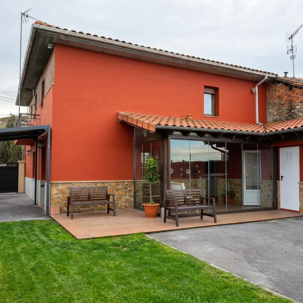 Casa con la fachada pintada en rojo, porche y jardín