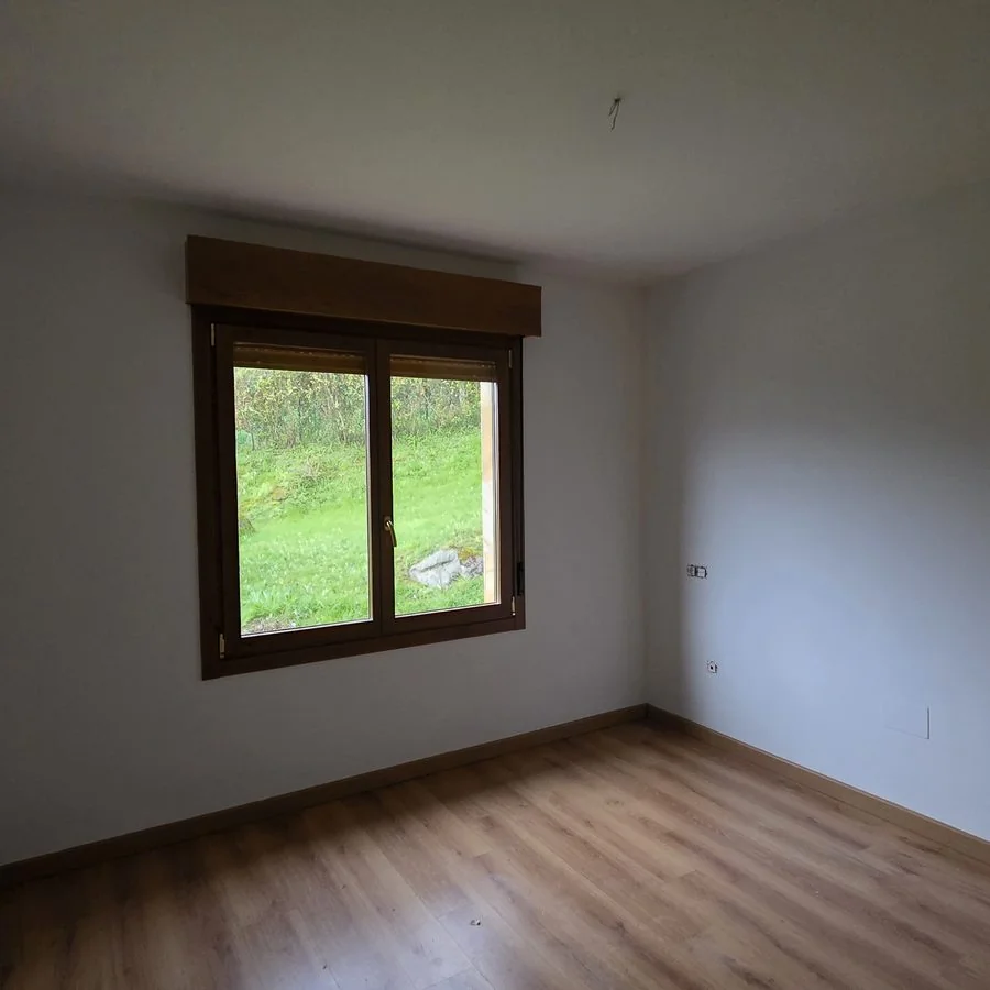 Habitación con las paredes recién pintadas y una ventana al jardín en La Fresneda, Siero