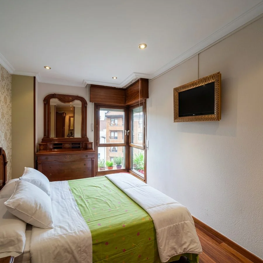 Dormitorio con una pared pintada en verde y los techos y paredes recién pintados en La Guía, Gijón